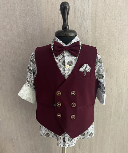 This wedding dress for small boy consists of a maroon Colored waistcoat, matching pants and a self-printed white Coloured shirt. It features a matching bow, a cute broach and a printed pocket square.