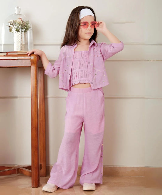 It Consists of a smocked crop top, pants and a jacket for a little girl. A Great option as a kid’s birthday wear. This dress has a beautiful bead detailing that uplifts the entire look.