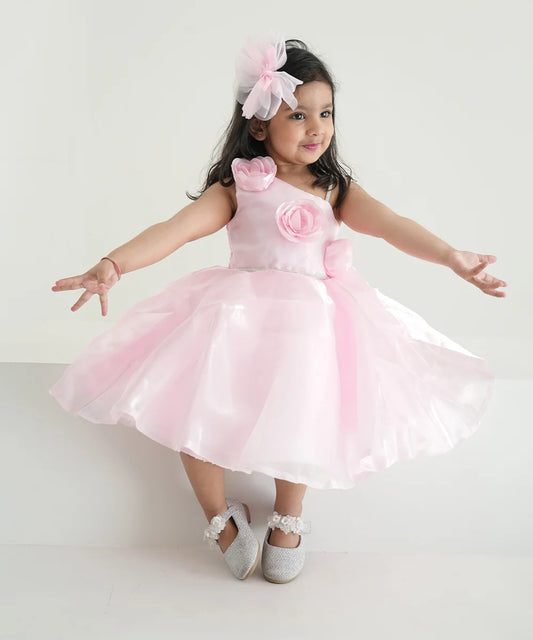 This is a beautiful baby pink coloured kids birthday frock that comes with a back zip closure. It features cute floral detailing on the dress that adds grace to the look.