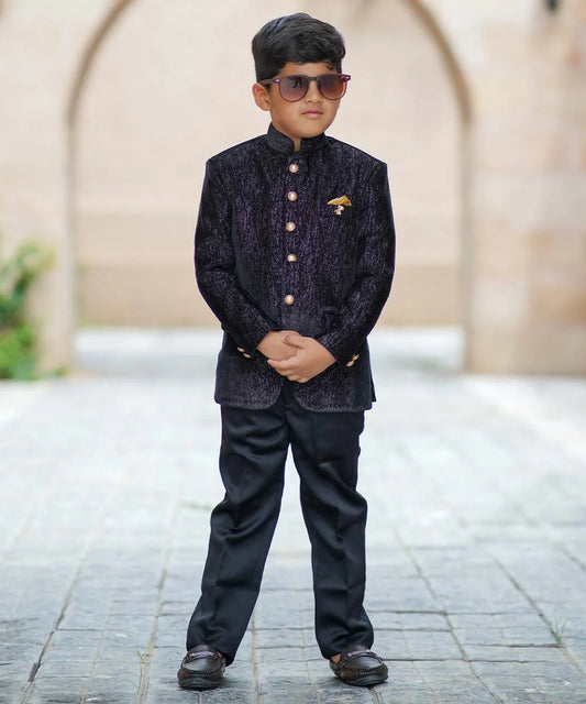 It consists of a black Colored full-sleeved Jodhpuri paired with matching black pants enhanced by shimmer lines and an elegant broach. 