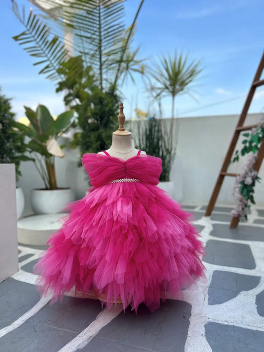  It's a pink coloured off-shoulder party-wear baby girl gown featuring a belt-style waist look.