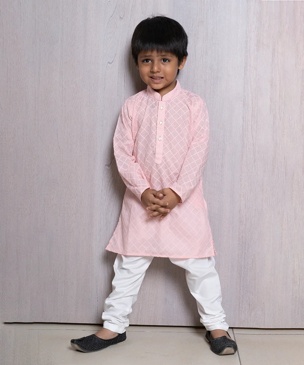It is a smart pink colored full sleeved Chickankari kurta paired with a white colored pajama.  This Kurta features the stylized buttons.