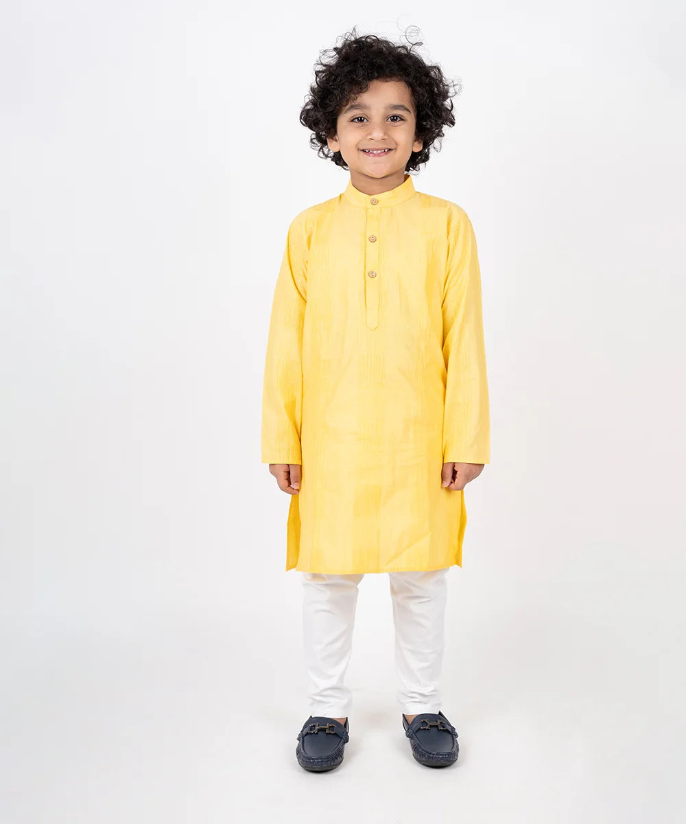 Crafted from cotton material, it features a full-sleeved yellow colored kurta teamed up with a matching pajama, enhanced by the wooden button detailing and pin tucks detailing.