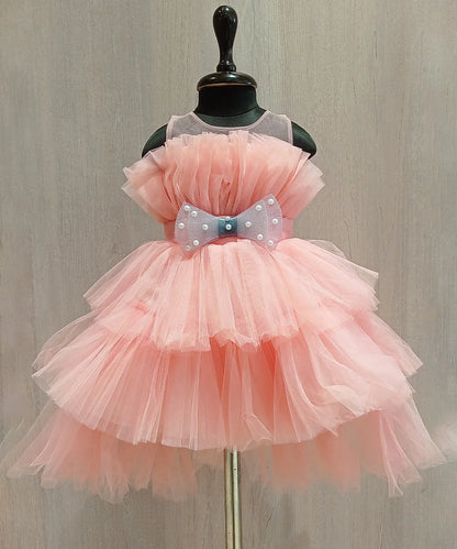 It’s a peach Colored up and down dress that comes with a zip closure. It features a big bow with pearl detailing on it.