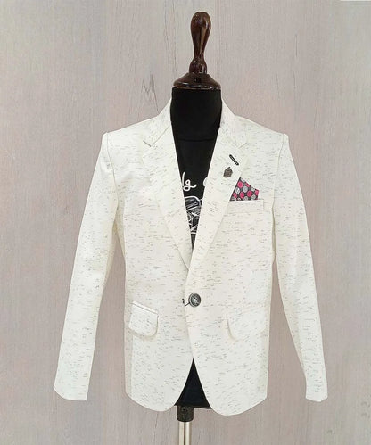 It is a smart cream color textured blazer for your kid boy that comes with a cool black round neck and half sleeved t-shirt. It features a stylized broach on a classic notch lapel collar.