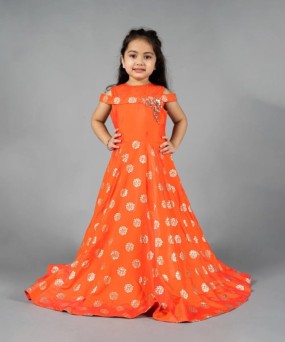 It is a orange Colored fit and flare long dress that comes with the back zip closure. It features floral embroidery detailing on the dress and comes with a fabric belt to be tied at the back.