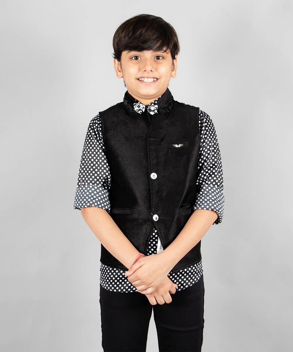 It is a beautiful black velvet waist coat with polka dot shirt for boys. The entire set consists of a waistcoat jacket, a polka dotted shirt and a printed bow. 