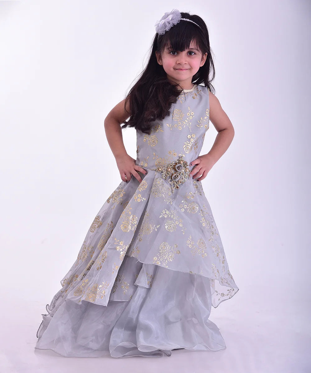 It is a beautiful grey Coloured stylish gown for girls that comes with a back zip closure. It features floral embroidery detailing on the dress and comes with a fabric belt to be tied at the back.