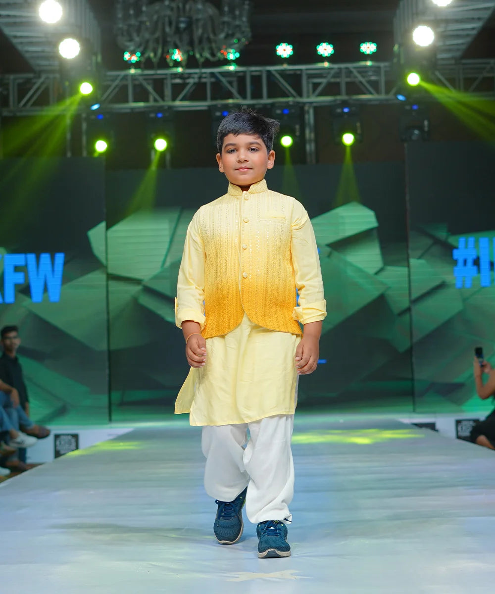 This kurta pajama set comes with a solid yellow colored full sleeves kurta, off-white elasticated Salwar and the ombre yellow jacket that features a stand collar neck and Chickankari pattern.