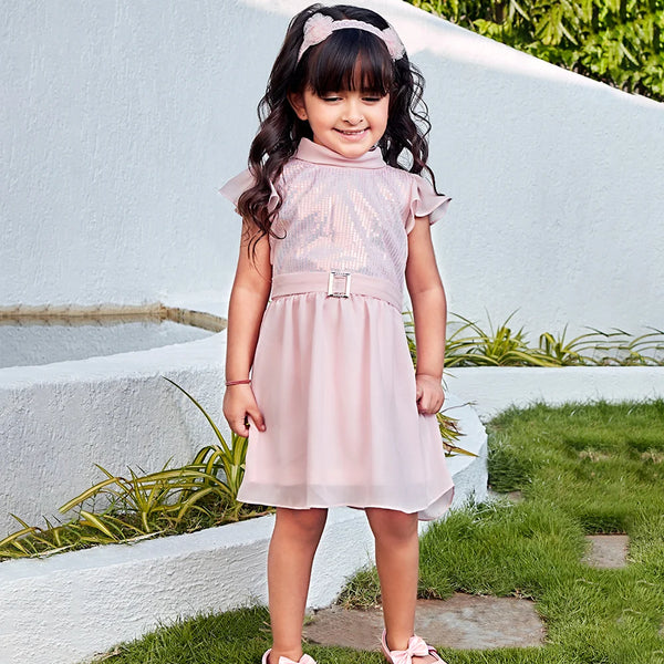 It is a pink shimmer dress that comes with a back zip closure. It features sequin fabric detailing on the yoke part and comes with a non-functional belt to add style to the look.