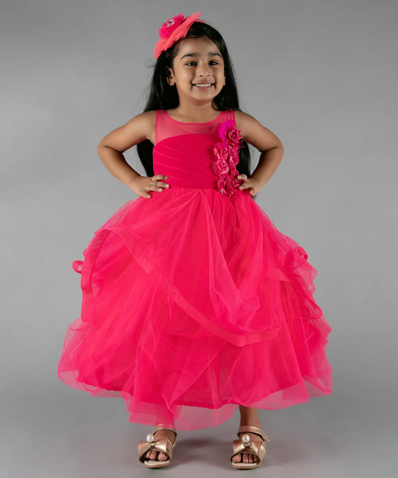 It’s a pink party gown for kid girl that comes with the back zip closure. It features floral as well as feather work on the dress and comes with the fabric belt to be tied at the back.