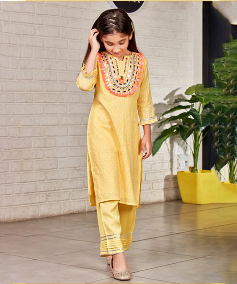 This yellow party wear clothes consists of a fancy kurta that comes with a back zip closure and a matching pant perfect for ceremonies. It features embroidered neck, lace on pant and sleeves. Moreover, sleeves come with the beautiful frill detailing and pant has pleated detailing on it.