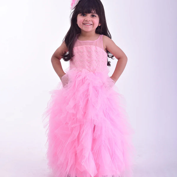  It’s a pink Colored frill birthday gown for kids that comes with the hook closure at the back with pearl detailing on it. It features a big bow at the back, pearl work detailing and comes with the fabric belt to be tied at the back.