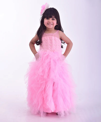  It’s a pink Colored frill birthday gown for kids that comes with the hook closure at the back with pearl detailing on it. It features a big bow at the back, pearl work detailing and comes with the fabric belt to be tied at the back.