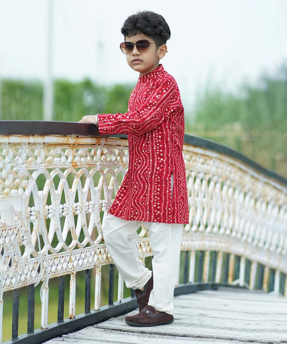 This red Bhandej kurta is crafted from a breathable cotton fabric for optimal comfort and is paired up with matching white pants. 