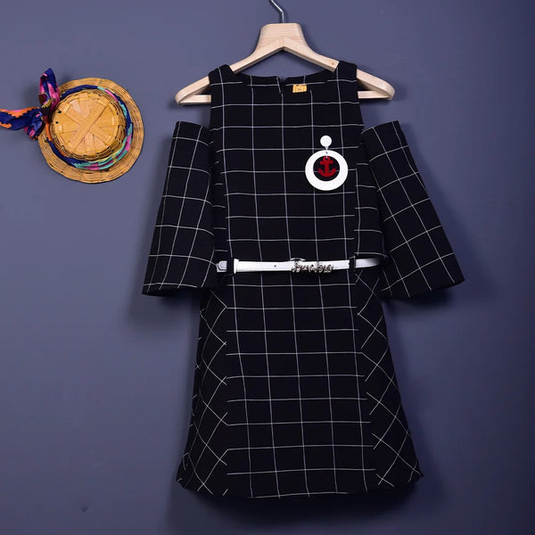  It is a black and white checked dress with a belt. It comes with a cute broach and a belt with a written inscription on it.