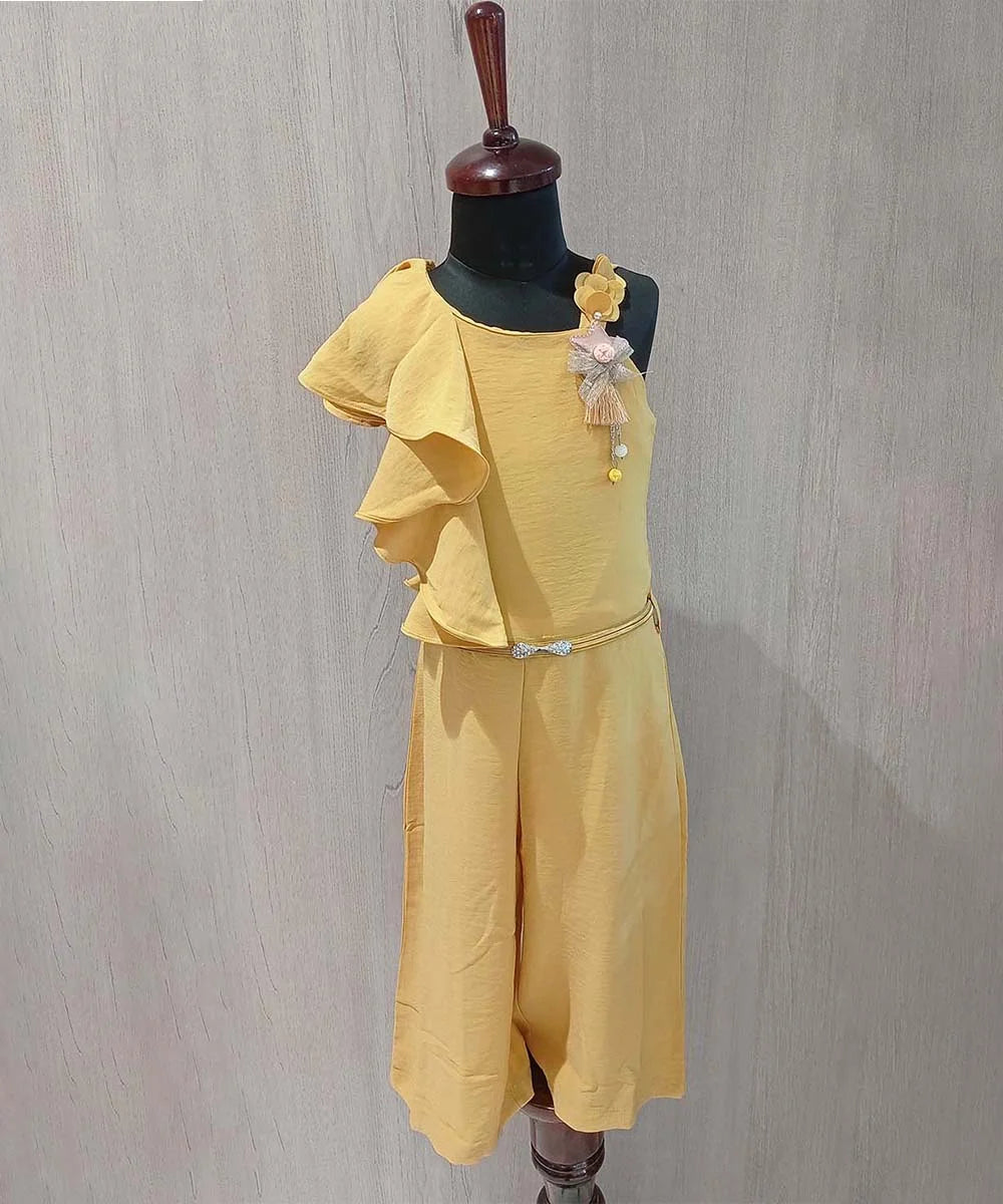 It is a mustard Colored jumpsuit for baby girls and is the best children birthday dress. It comes with a matching belt, ruffled detailing on one shoulder and a star broach detailing.