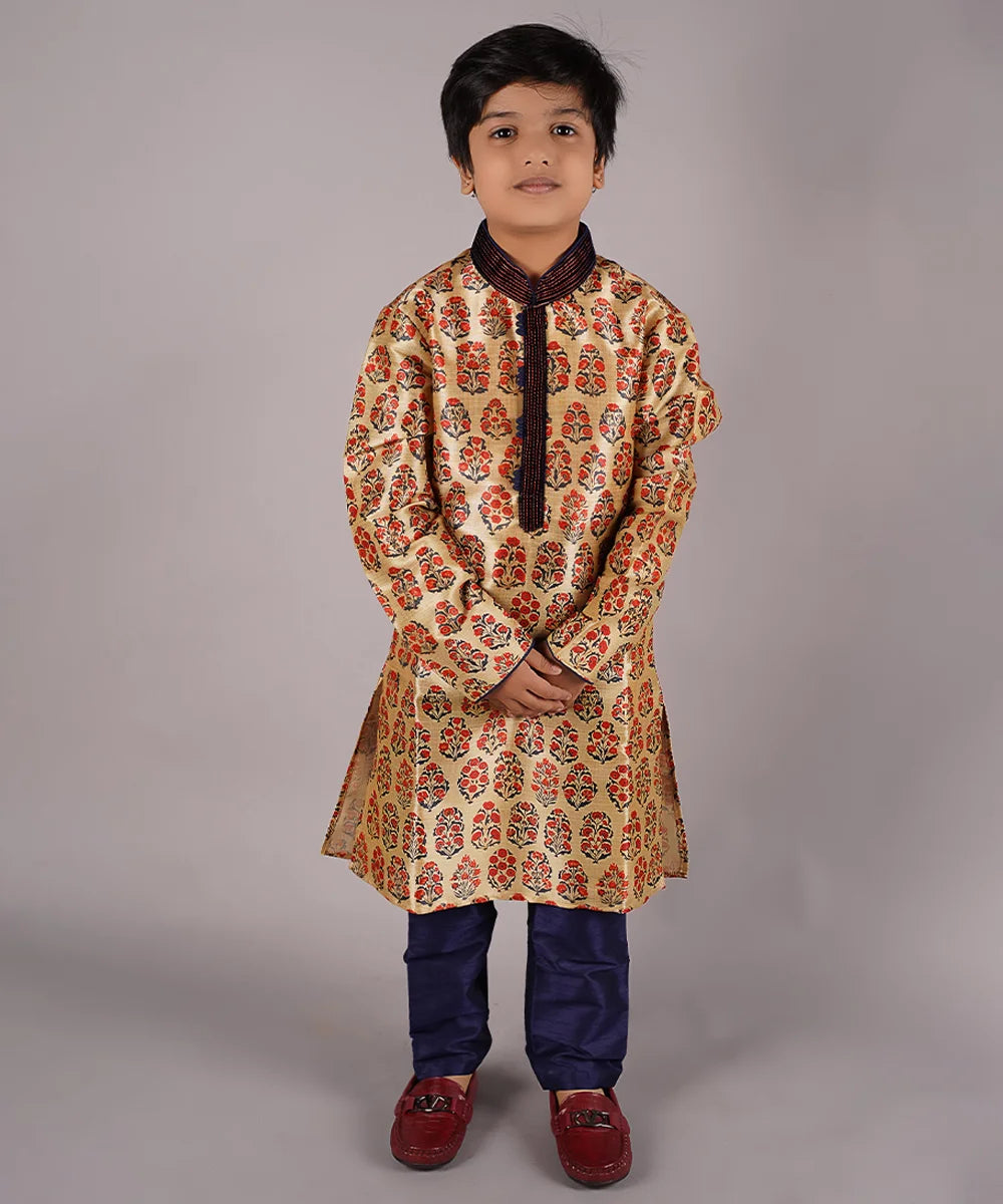  It is a full sleeve beige Colored traditional kurta for boys paired up with a navy blue Colored pyjama. This kurta curated from raw silk fabric features mandarin collar and placket curated from thread detailing done on velvet fabric while the pyjama features an elasticated waist to keep him at ease.