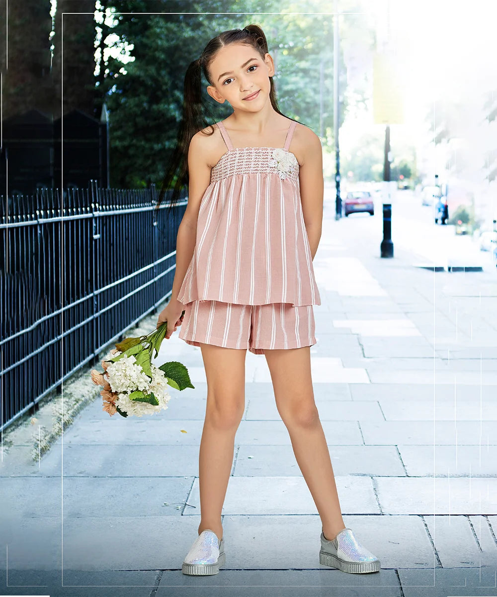  It Consists of a light pink Colored top and shorts for little girl. This dress has floral detailing on it that adds grace to the look.