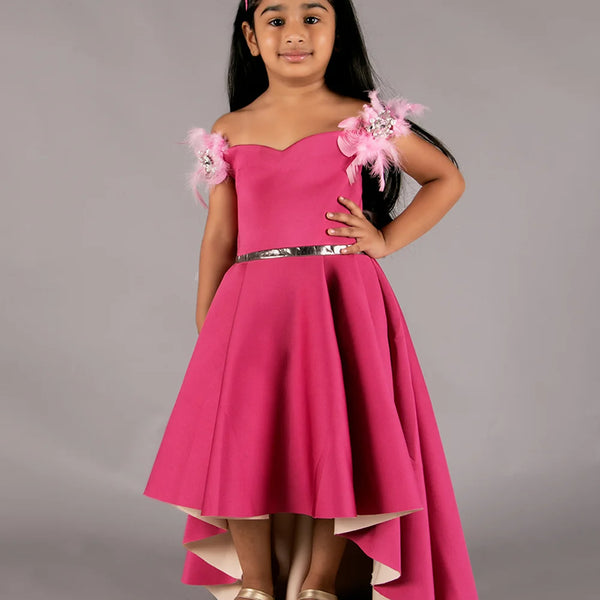 It’s a pink Colored high-low party wear gown for girls with some pleated detailing on it. It features pearl and feather work detailing that adds elegance to the dress.