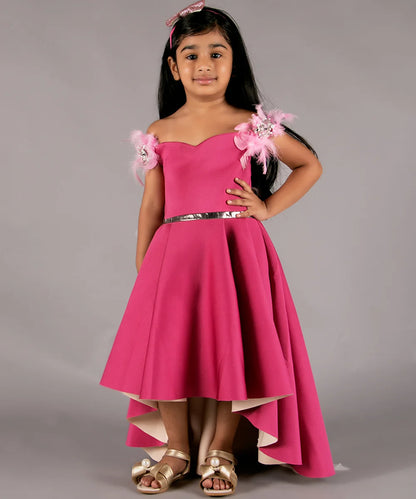 It’s a pink Colored high-low party wear gown for girls with some pleated detailing on it. It features pearl and feather work detailing that adds elegance to the dress.
