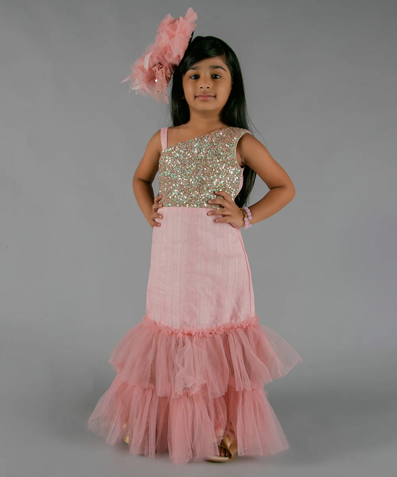 It’s a pink ruffle gown that comes with the back zip closure. It features ruffle detailing and the fabric belt to be tied at the back.