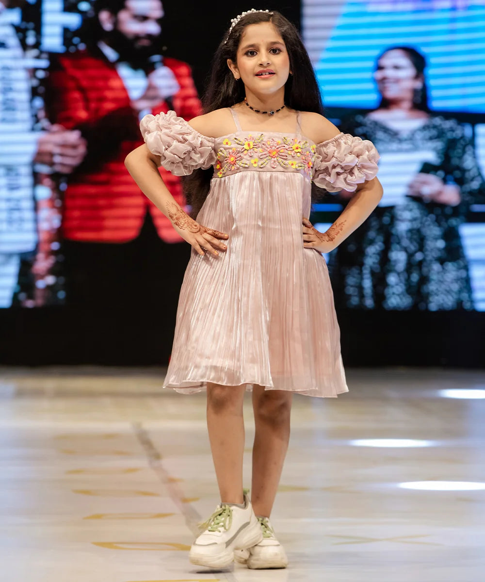 It’s a very light onion pink Colored girl party dress online that’s perfect for occasions. It features designer floral work and a smocking sleeves