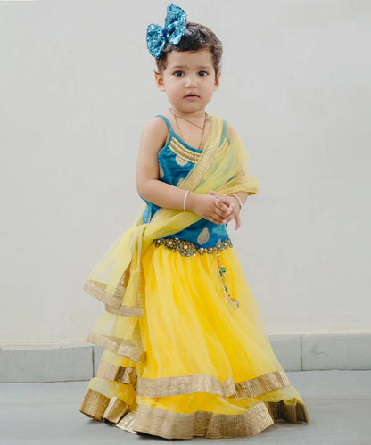 This  blue and yellow lehenga consist of a choli, a layered lehenga, a dupatta and comes with a back hook closure. It features beads work on neck, tassels and floral work on the waist of lehenga. 