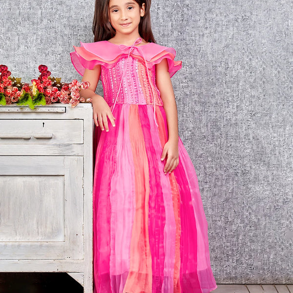 This pink and peach Colored dress consists of a gown and a short triple layer cape. It features floral work on the yoke part of the gown.