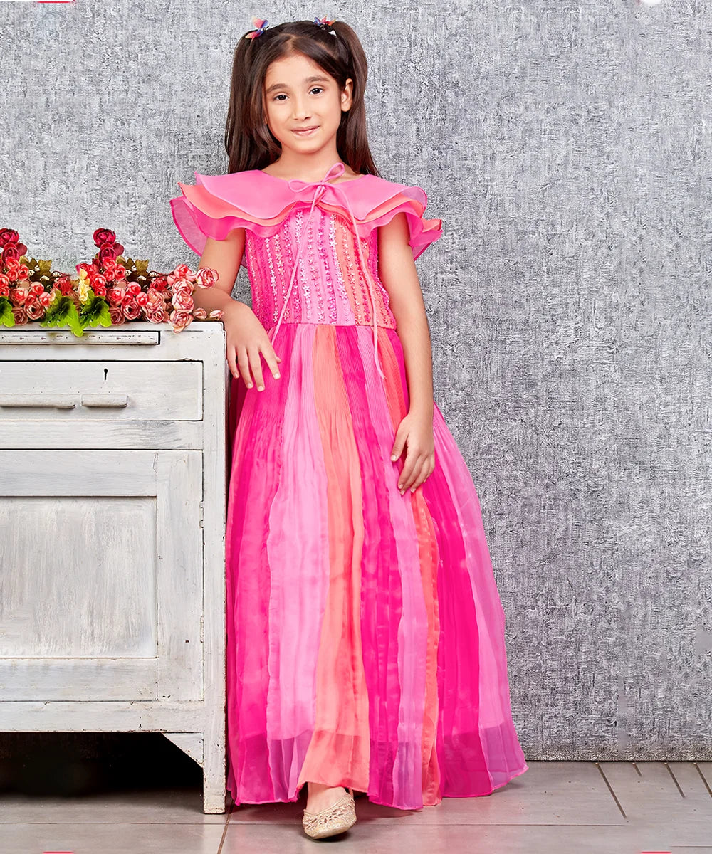 This pink and peach Colored dress consists of a gown and a short triple layer cape. It features floral work on the yoke part of the gown.