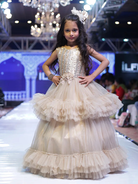 It’s a double layer ruffle girls birthday gown that comes with the back zip closure. Moreover, it is paired up with short sleeves that can be stitched as per requirement. It features floral detailing on the waist and comes with the fabric belt to be tied at the back.