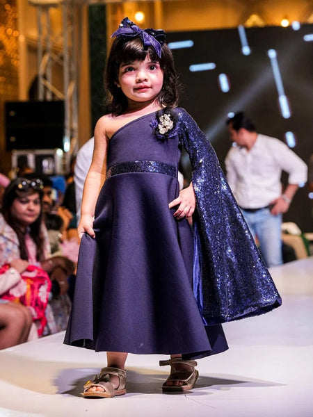 It’s a navy gown that comes with the back zip closure. It features big flower detailing and the fabric belt to be tied at the back.