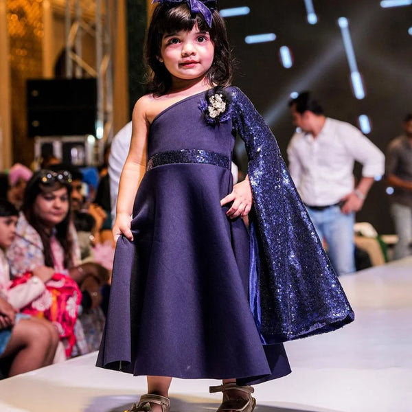 It’s a navy gown that comes with the back zip closure. It features big flower detailing and the fabric belt to be tied at the back.