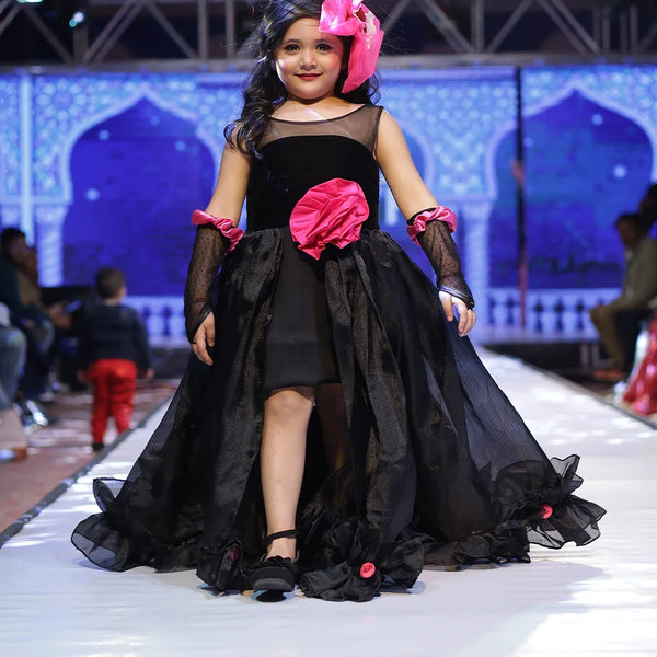 It’s a stylish black gown for girls that comes with the back zip closure. It features big flower on the waist and small floral detailing on the ruffles present at the bottom side of the gown.