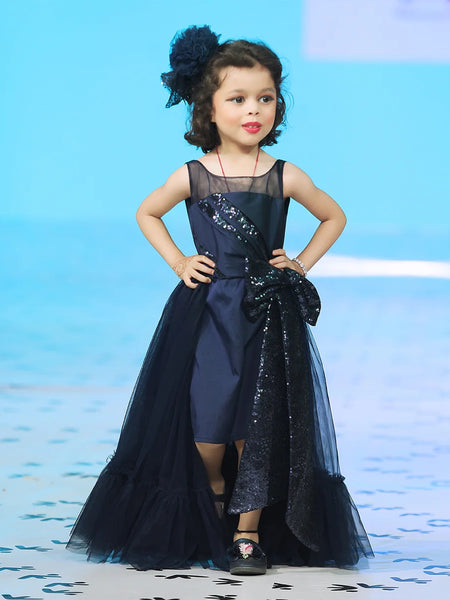 It’s a beautiful navy gown for kids with trail that comes with the back zip closure. It features big sequin bow on the waist and pleated detailing on the yoke that adds grace to the look.