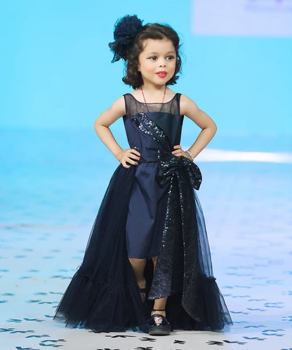 It’s a beautiful navy gown for kids with trail that comes with the back zip closure. It features big sequin bow on the waist and pleated detailing on the yoke that adds grace to the look.