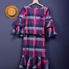It is a multi Colored checked dress with a white belt for girls. This dress comes with floral and stone detailing and the belt has a written inscription on it.