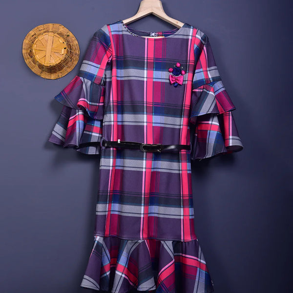 It is a multi Colored checked dress with a white belt for girls. This dress comes with floral and stone detailing and the belt has a written inscription on it.