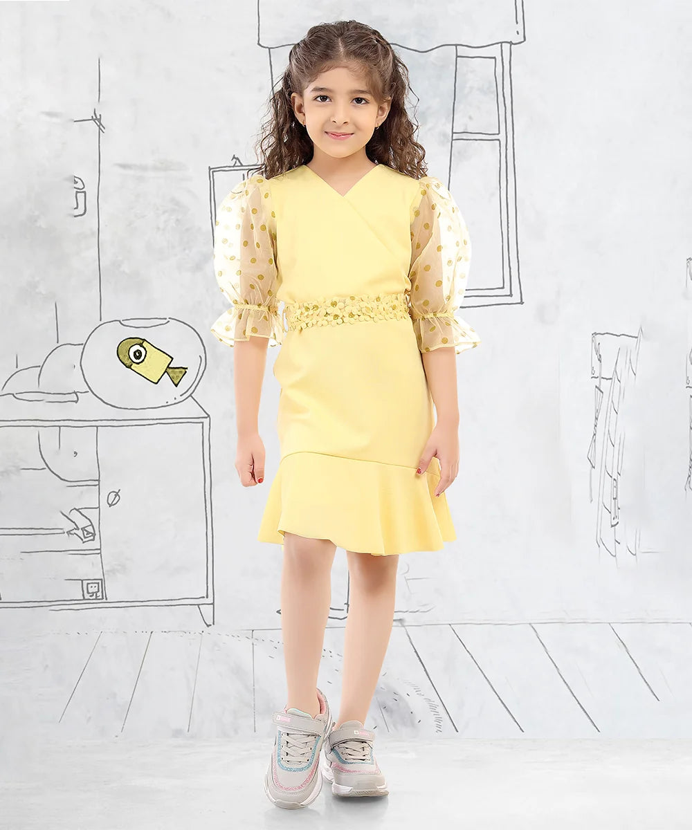 It’s a yellow party dress that comes with a back zip closure. It features polka dots on the sleeves and a matching floral belt.