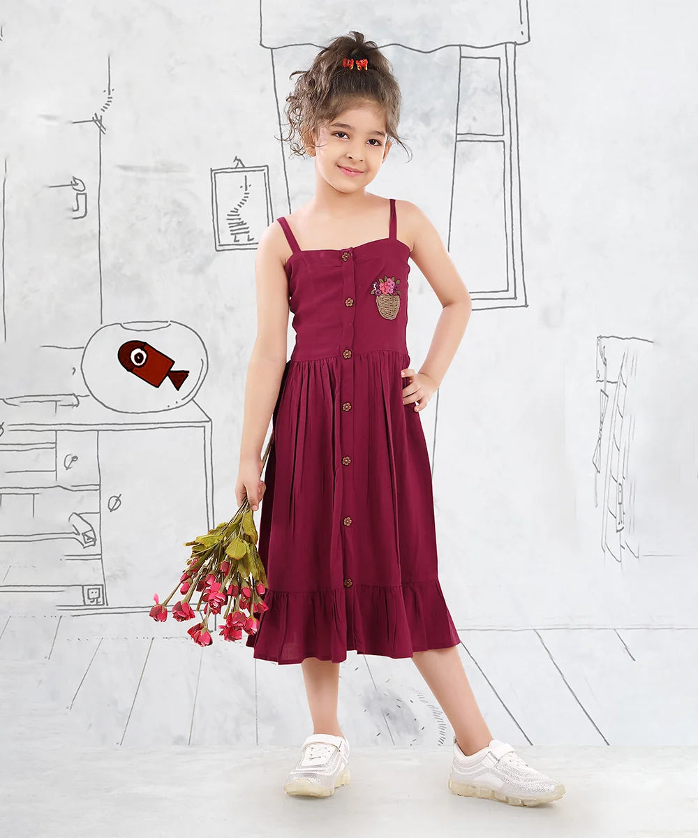It is a Maroon Colored birthday girl frock that comes with a front button closure for girls. It features beautiful floral basket embroidery on the dress.
