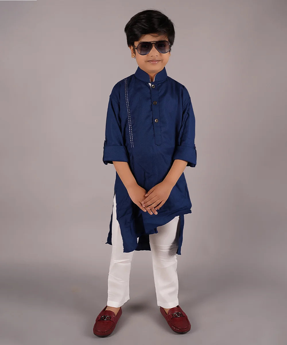This pathani kurta pajama set comes with a solid navy blue colored full sleeved asymmetric kurta and cream colored Salwar, curated from best quality cotton voile fabric. 
