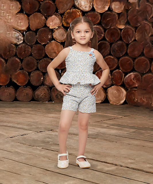 This light green outfit Consists of a printed peplum top and shorts for kid girls. Shorts have two pockets and have floral work detailing on top and bottom.