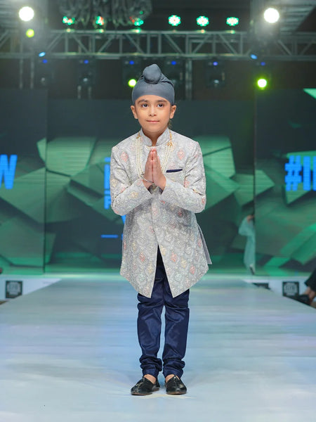 It is a beautiful steel-colour self-embroidery Sherwani for a wedding function for boys paired up with a navy colour Churidar Pyjama.