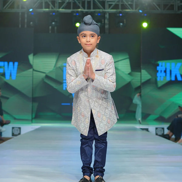 It is a beautiful steel-colour self-embroidery Sherwani for a wedding function for boys paired up with a navy colour Churidar Pyjama.