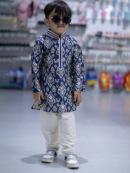It is a full sleeve indigo blue Colored printed kurta paired up with a cream coloured pyjama. This kurta curated from raw silk fabric that features thread detailing done on collar and placket while the pyjama features an elasticated waist to keep him at ease.