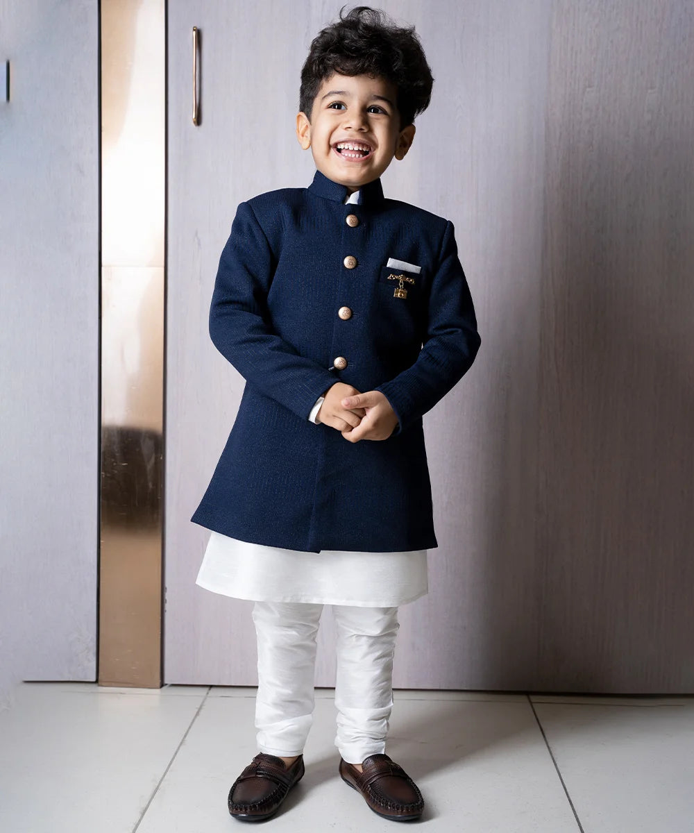 It is a self-textured navy blue colour achkan that comes with a white coloured kurta and matching Churidar Pajama with a beautiful broach. Moreover, the fabric that has been used to make it, is of the topline quality.