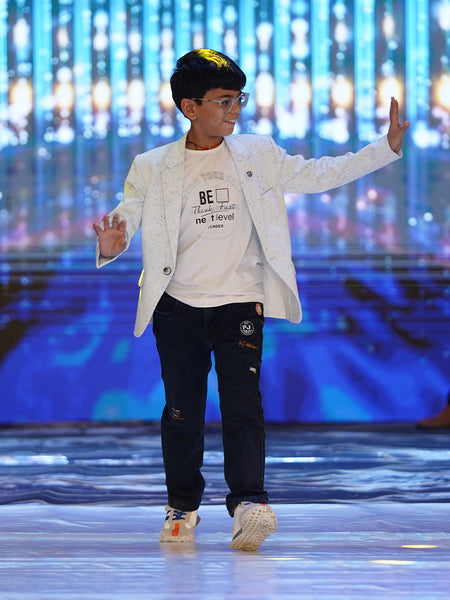 This boys birthday outfit consists of a self-printed light blue coloured Blazer and a matching self-printed white Colored t-shirt. It features a cute broach and a black coloured pocket square.