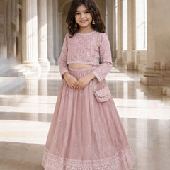Young girl in a pink traditional outfit standing in a grand hall with columns.