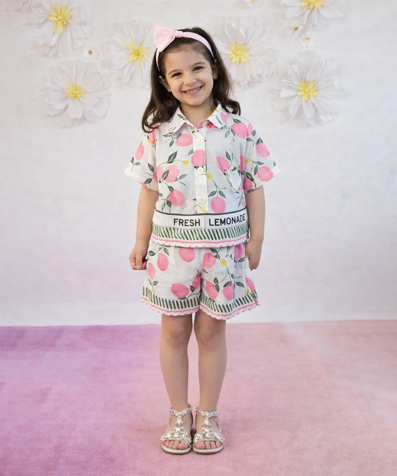 Child wearing a floral outfit with 'Fresh Lemonade' text against a floral background