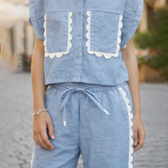 Person wearing a blue outfit with white trim on a blurred background